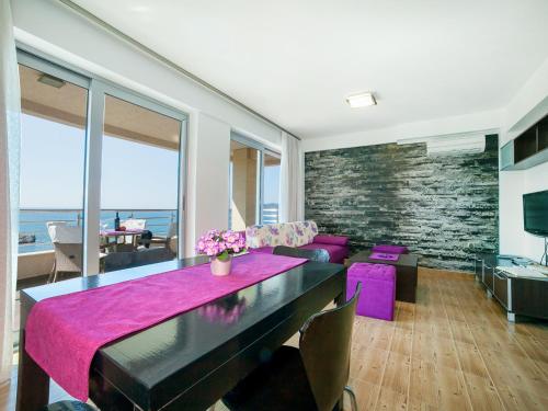 a living room with a table and purple chairs at Apartments Raymond in Sveti Stefan