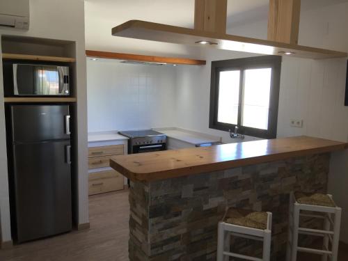 a kitchen with a black refrigerator and a counter at Apartamentos DELFIN in Es Calo