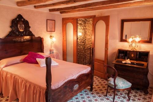 a bedroom with a bed and a table and a chair at Cal Calaf in Vilardida