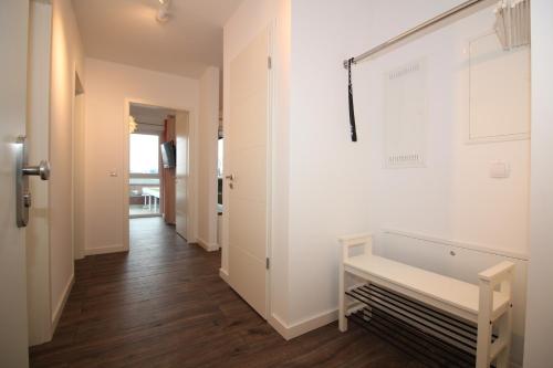 a hallway with white walls and a white bench at Wohnen am Yachthafen W48 in Cuxhaven