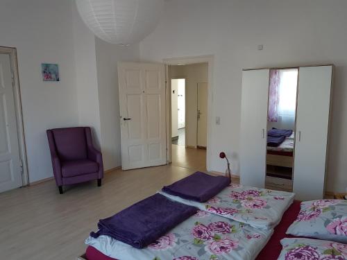 バート・ケーゼンにあるThüringer Hausのベッドルーム1室(ベッド2台、紫色の椅子付)