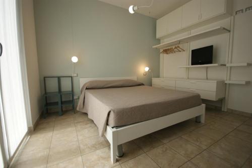 1 dormitorio con 1 cama y TV en Residenza Alpaluba, en Vasto