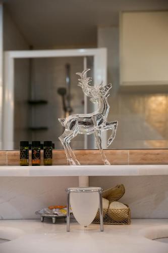 a glass figure of a deer sitting on a counter at Villa Sunrise Lagonisi in Lagonissi