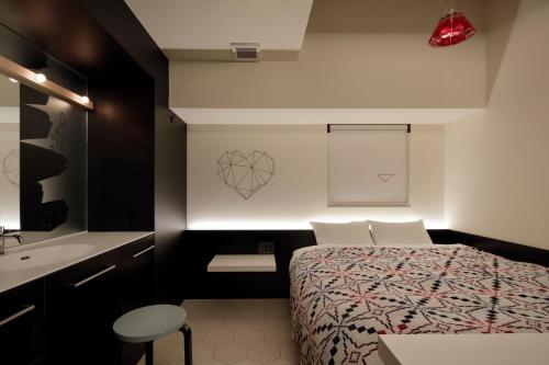 Dormitorio pequeño con cama y lavamanos en Third Place Hotel en Saitama
