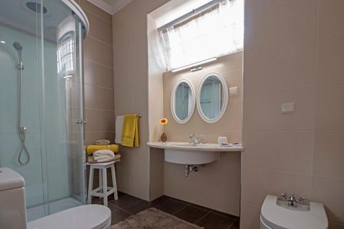 a bathroom with a toilet and a sink and mirror at Quinta do Bom Sucesso in Funchal