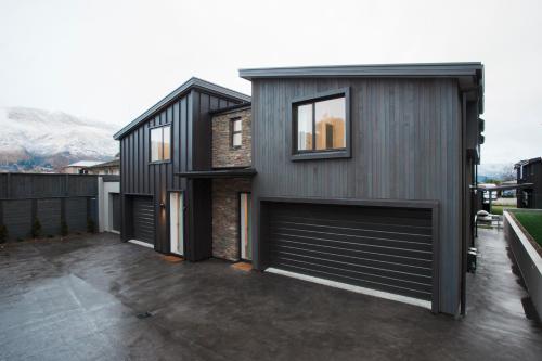 a house with two garage doors on the side of it at Dungarvon Street Apartments in Wanaka