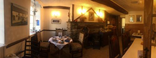 a dining room with a table and a fireplace at Borderers Inn in Brecon
