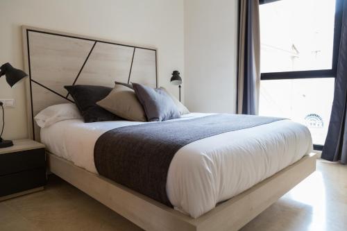 バレンシアにあるNew Aloha Apartment Center Valenciaのベッドルーム1室(大型ベッド1台、白いシーツ、枕付)