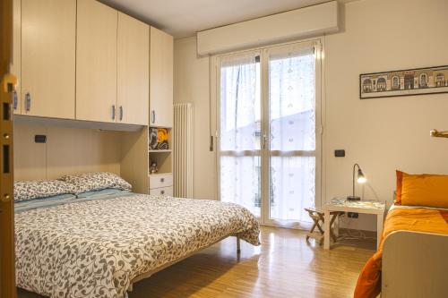 a bedroom with a bed and a desk and a window at Casa Rosa in Luisago