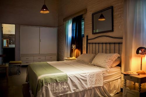 ein Schlafzimmer mit einem Bett, einem Schrank und Lampen in der Unterkunft Vila Alba in Fortim
