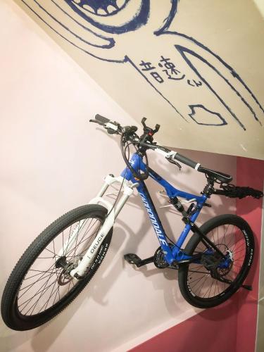 a bike hanging on a wall in a room at Otohaya Guesthouse in Nagoya