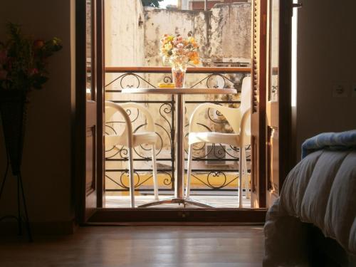 a room with a table and chairs on a balcony at Narkissos 'SUPERB' in Chania Town