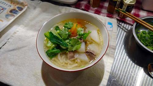 a bowl of soup with vegetables in it on a table at 高寮貳陸之貳民宿 Gaoliao 26-2 Simple Home Life in Yuli