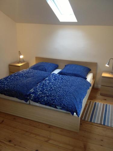a bedroom with a bed with blue blankets and pillows at Apartment Villa Elisa in Bad Kreuznach