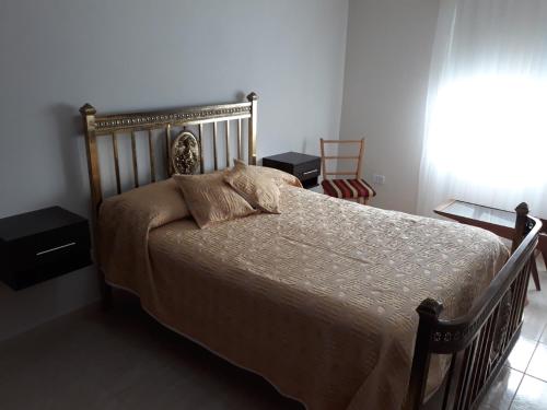 a bedroom with a bed and two tables and a window at Navarro Departamentos Temporarios in Navarro