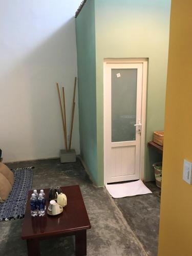 a room with a door and a table with water bottles at The Kadupul Homecation in Da Lat