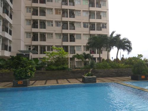 a swimming pool in front of a tall building at DSR Margonda Residence 3 Apartment in Depok