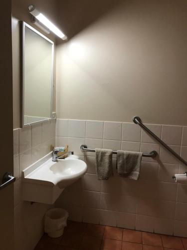 a bathroom with a sink and a mirror at Heritage Resort in Weipa