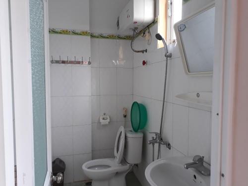 La petite salle de bains est pourvue de toilettes et d'un lavabo. dans l'établissement Khách sạn Hưng Vân - Bắc Kạn city, à Bak Kan