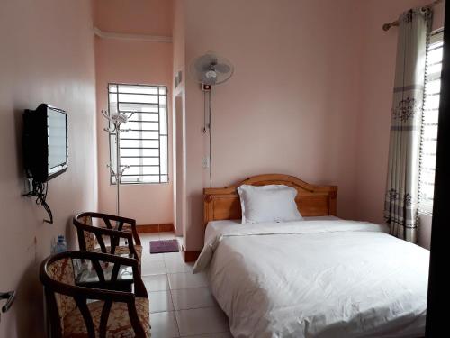 sypialnia z łóżkiem, telewizorem i oknem w obiekcie Khách sạn Hưng Vân - Bắc Kạn city w mieście Bak Kan