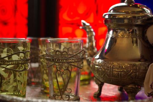 un tavolo con bicchieri e un bollitore per il tè di Riad Ibn Battouta & Spa a Fes