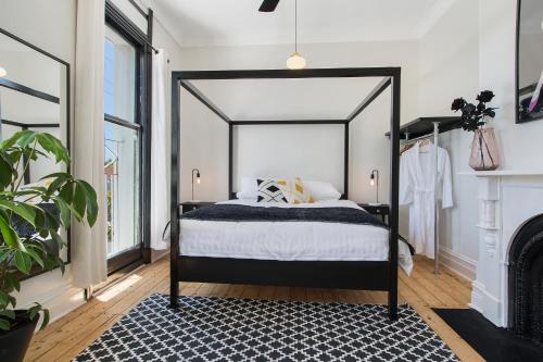 a bedroom with a black and white bed and a fireplace at The Local Hotel in Fremantle