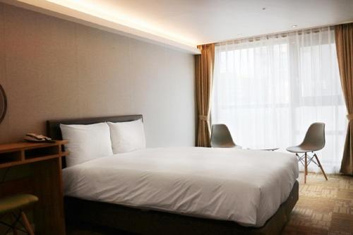 a hotel room with a bed and a window at Royal Square Hotel Seoul in Seoul