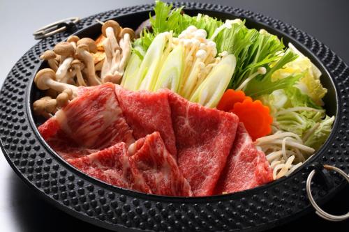 a black bowl of food with meat and vegetables at Unzen Fukudaya in Unzen