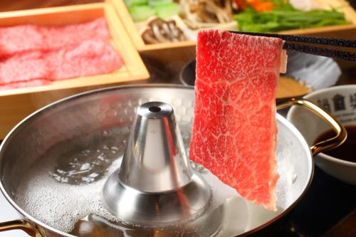a piece of meat is in a pot with water at Unzen Fukudaya in Unzen
