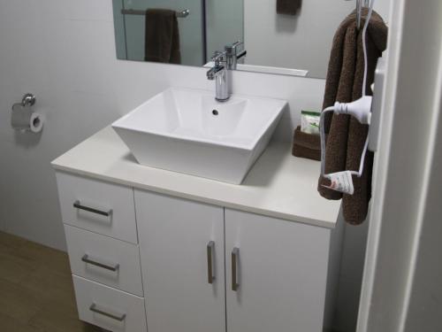 a bathroom with a white sink and a mirror at Sunnybank Star Hotel in Brisbane