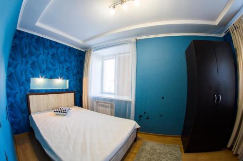 オムスクにあるRENT-сервис Апартаменты на Маркса 26の青いベッドルーム(ベッド1台、窓付)