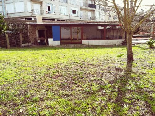 a tree in a yard in front of a building at Casa Guillan Illa de Arousa in Isla de Arosa