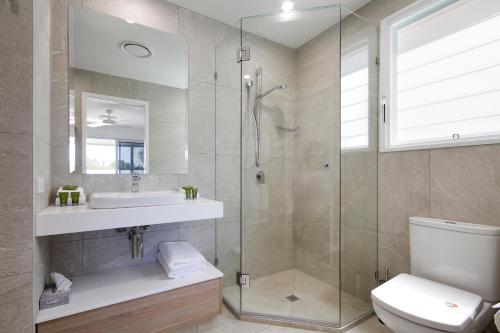 a bathroom with a shower and a sink and a toilet at Noosa Haven Apt 12 Riverfront Elegance in Noosaville