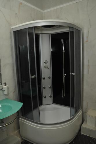 a shower with a glass enclosure in a bathroom at Hotel Royal (Отель Роял) in Poltava