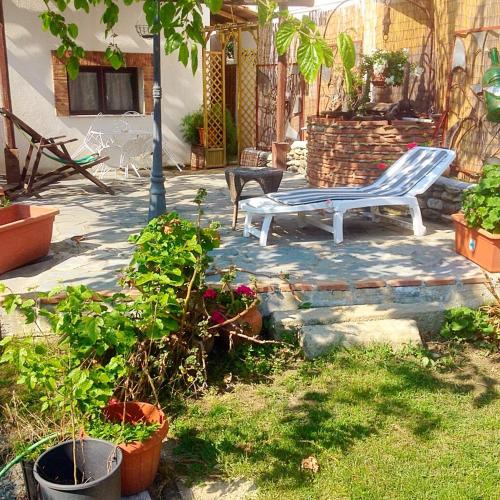 a patio with a white bench and some plants at Casa Vacanze Borgo Borghese in SantʼAlessio Siculo