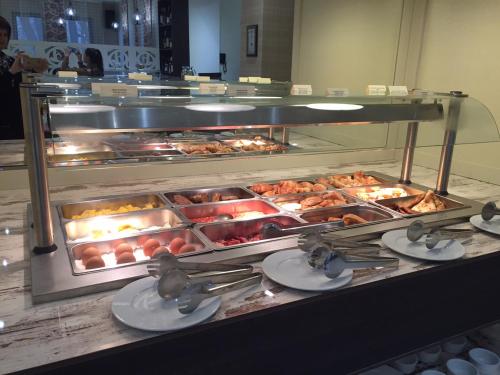 una línea de buffet con bandejas de comida en un restaurante en Strimon Garden Medical SPA Hotel, en Kyustendil