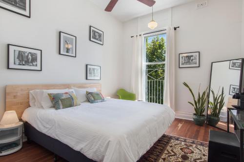 a bedroom with a large white bed and a window at The Local Hotel in Fremantle