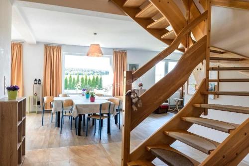 a dining room and kitchen with a table and a staircase at Dom Wakacyjny Quattro Niesulice in Niesulice