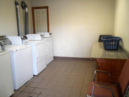 a laundry room with washers and dryers and a counter at Budgetel Inn Houston/Nasa in Webster