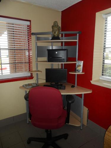 an office with a desk with a computer and a red wall at Budgetel Inn Houston/Nasa in Webster