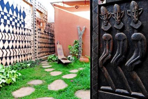 a garden with a fence and a gate with a door with antlers at Maison d'hôtes Chez Giuliana in Ouagadougou