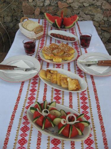 een tafel met daarop borden met eten bij Robinson Sunset Guest House in Ohrid