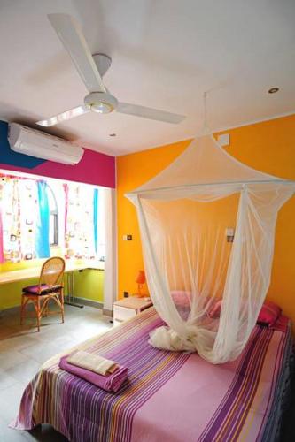 a bedroom with a bed with a mosquito net at Maison d'hôtes Chez Giuliana in Ouagadougou
