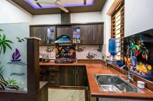 a kitchen with wooden cabinets and a sink at Friends Home Stay - Agra in Agra