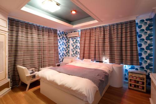 a bedroom with a bed and a window with curtains at Hotel Sunset (Adult Only) in Choshi