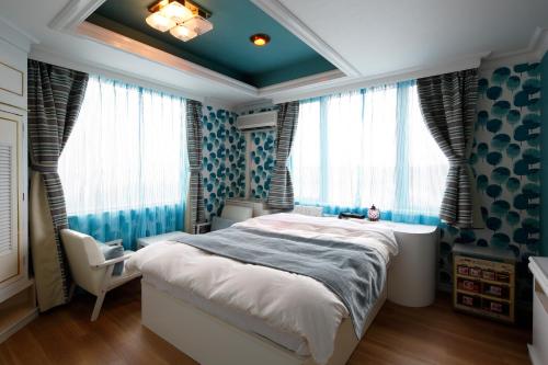a bedroom with blue walls and a bed and a window at Hotel Sunset (Adult Only) in Choshi