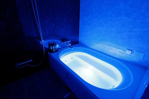 a blue bathroom with a tub in a blue room at Hotel Sunset (Adult Only) in Choshi