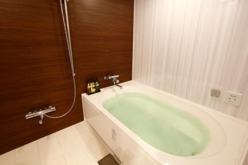 a bathroom with a green bath tub in a room at Hotel Sunset (Adult Only) in Choshi