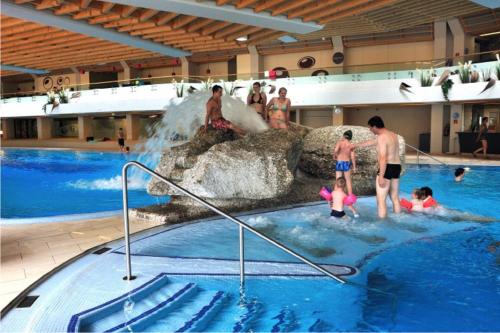 a group of people in a swimming pool with a waterfall at Hotel Schönegg in Seefeld in Tirol