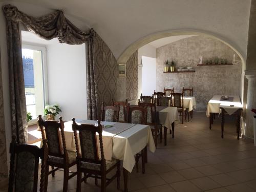 a restaurant with tables and chairs and a large window at Hotel Dvůr in Krnsko